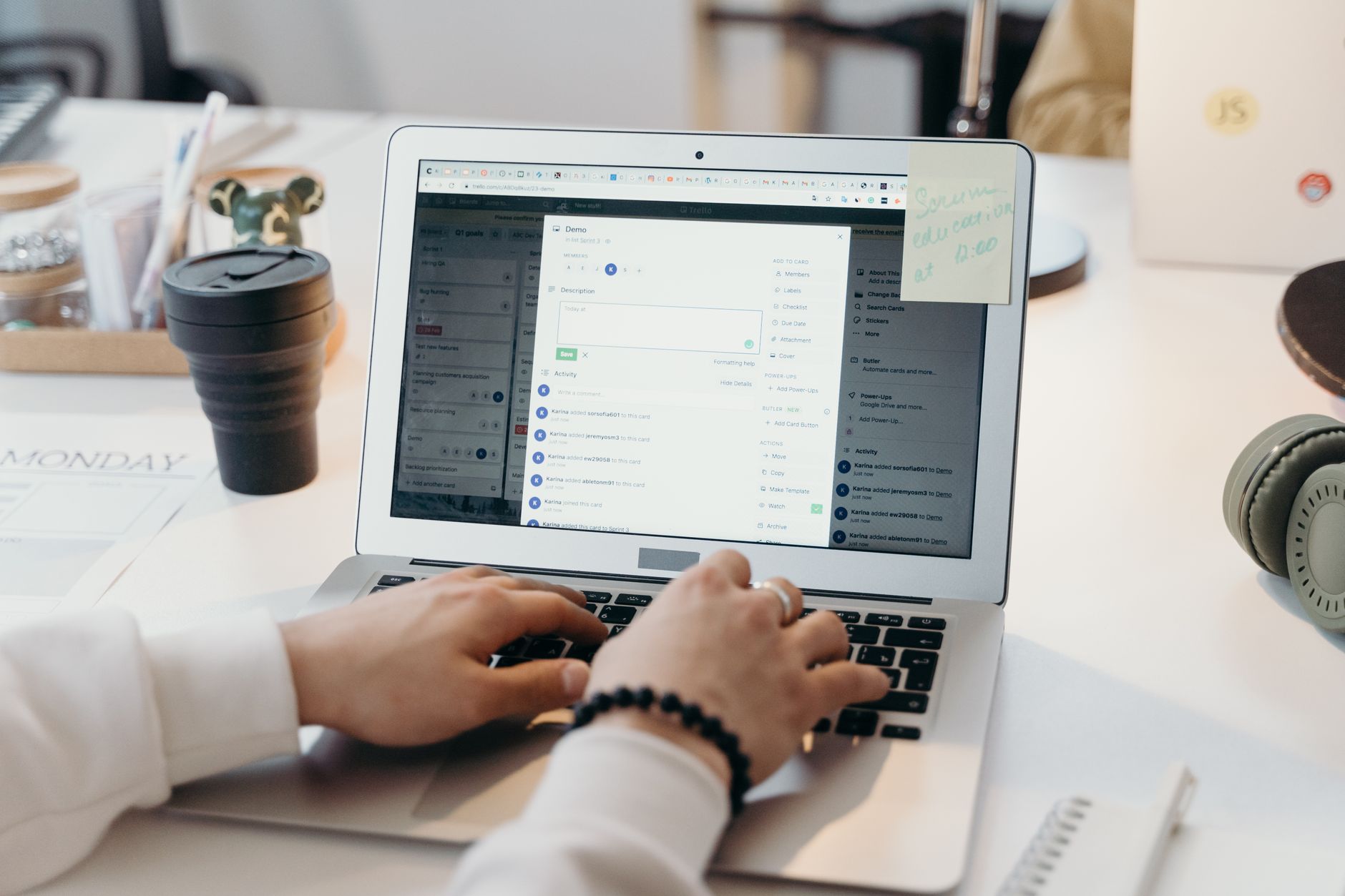 Person at a clean desk using a laptop that shows a calendar and email app with a coffee cup nearby.