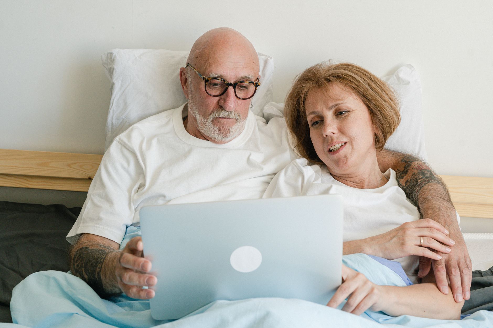 a senior couple sitting together and looking at a laptop screen while smiling