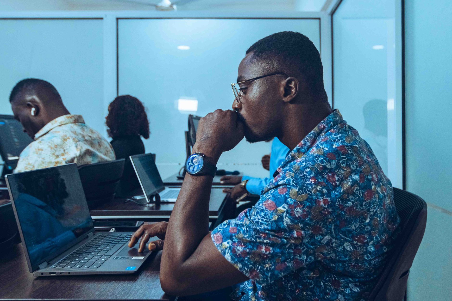 An adult student with a laptop taking notes in a workplace training workshop